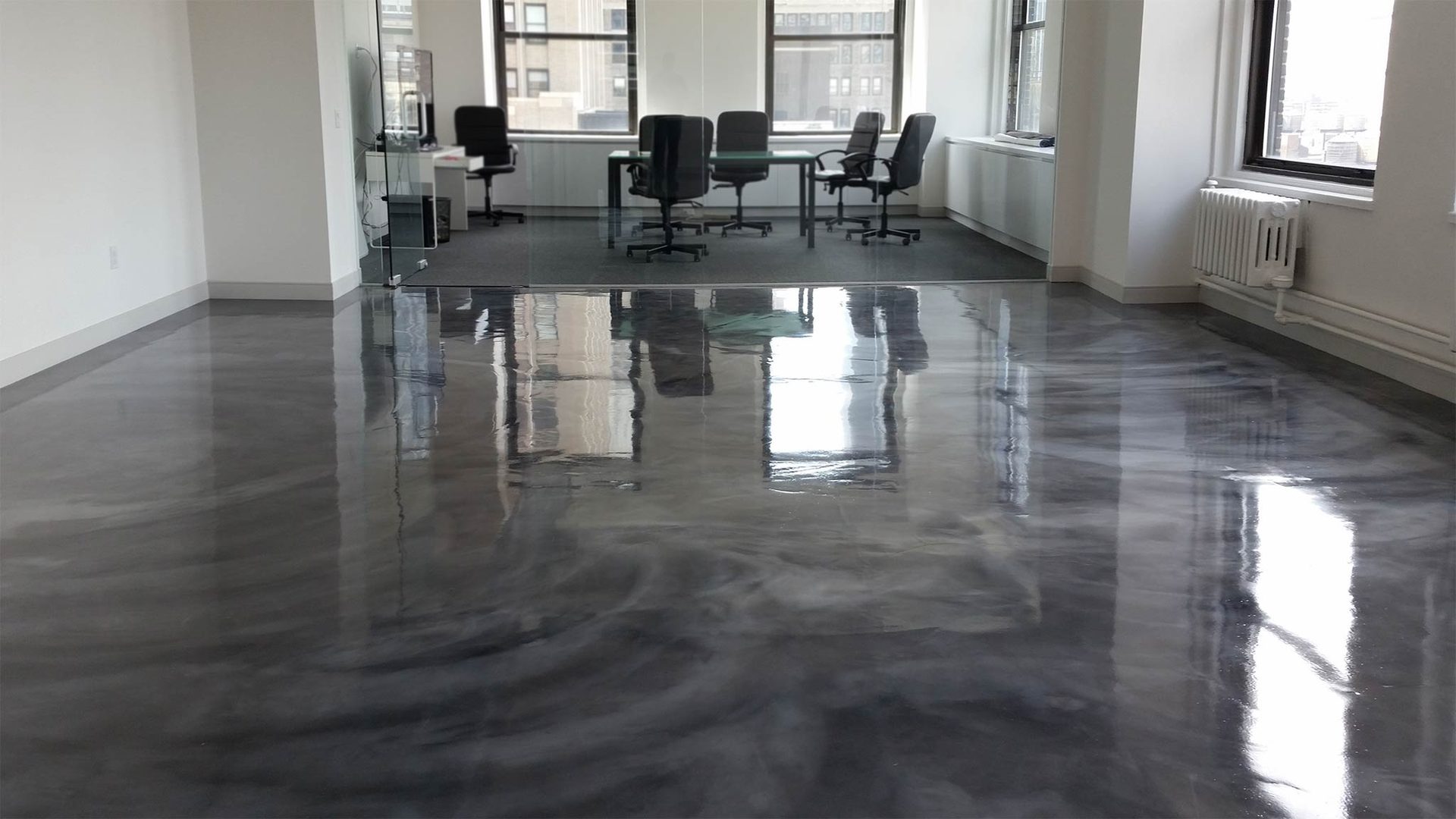 Office interior with a reflective dark metallic epoxy floor