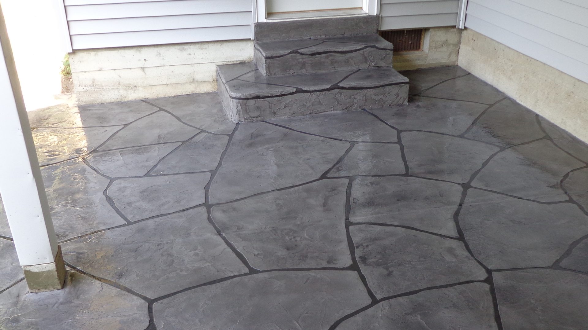 Resurfaced concrete patio and steps with a flagstone pattern